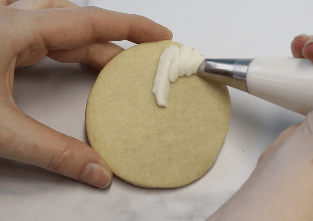 Start piping a petal from the center of the cookie