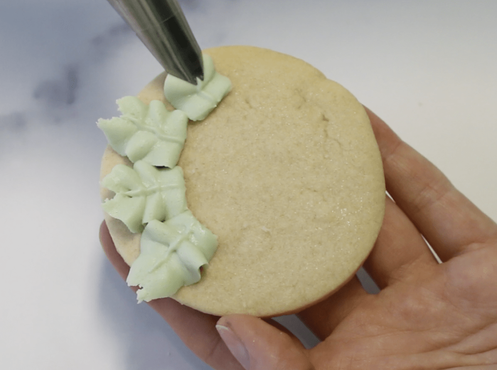 Pipe buttercream leaves on the outer edge