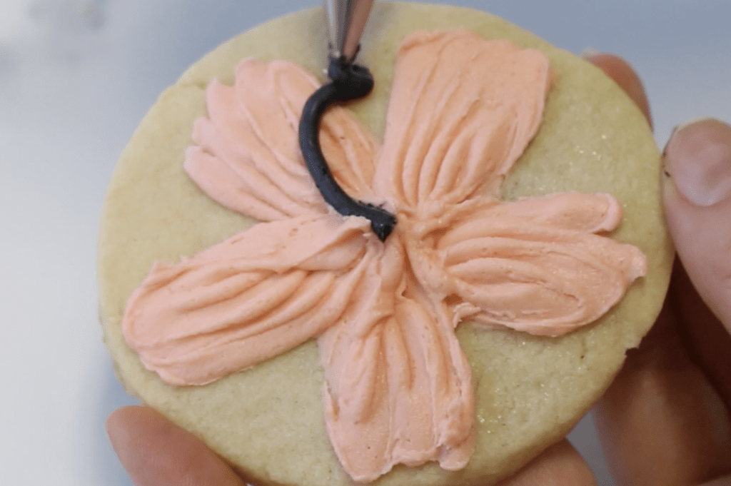 Add the stamen in the center with black buttercream